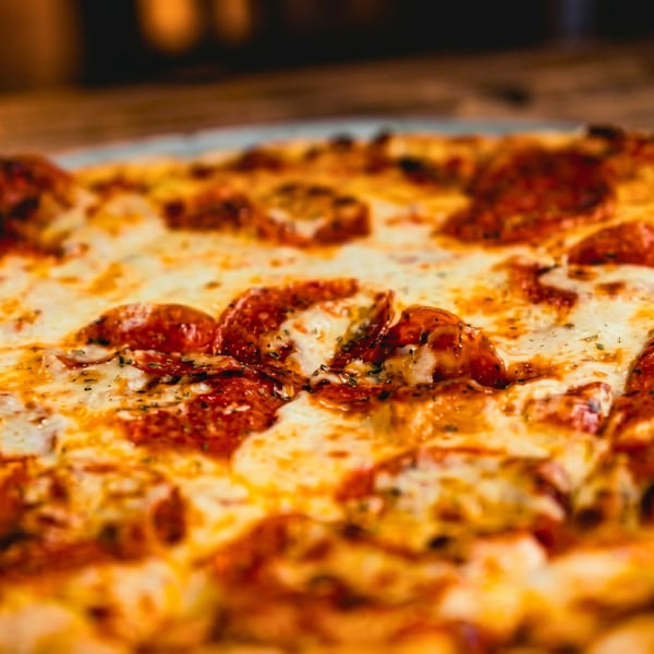 Close-up of a hot pepperoni pizza with melted cheese and herbs, ready to be served.
