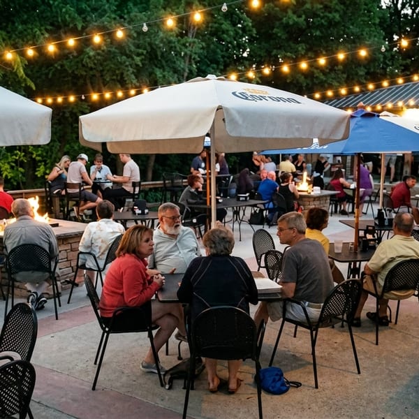 Patrons enjoying an evening on a restaurant patio with string lights, umbrellas, and fire pits.